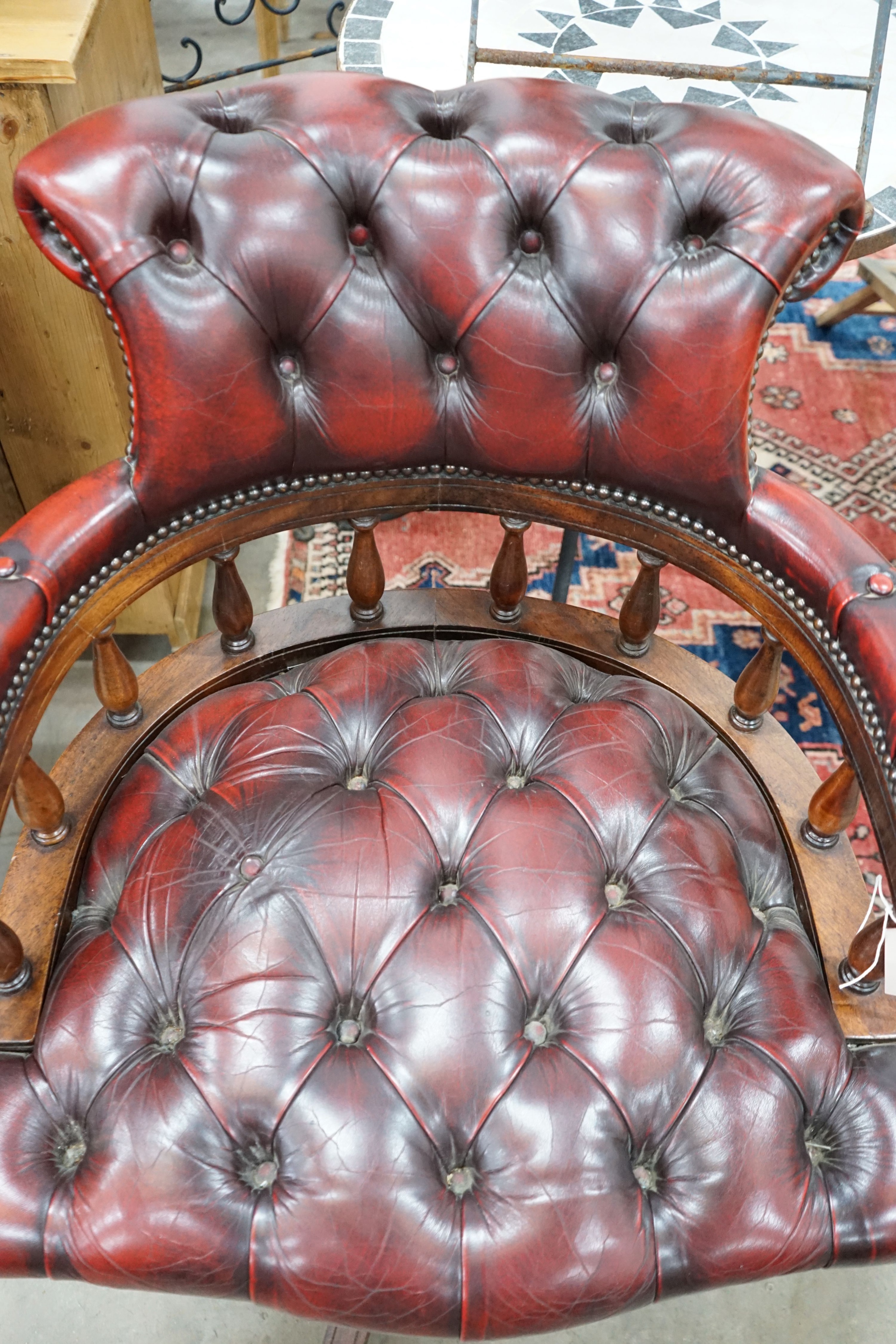 A reproduction Victorian style buttoned red leather upholstered swivel desk chair, width 63cm, depth 59cm, height 84cm